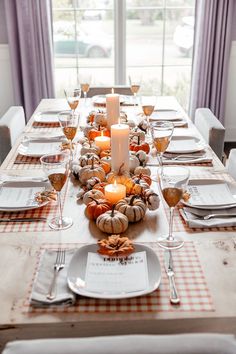 a table set with plates, silverware and candles