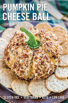 pumpkin cheese ball on a plate with crackers and green garnish in the middle