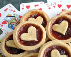 small pastries with hearts on them sit in front of playing cards