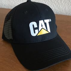 a black hat with the word cat on it sitting on top of a wooden table