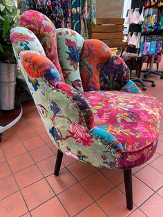 an upholstered colorful chair sitting on top of a tiled floor