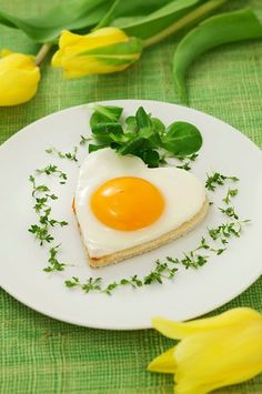 an egg is sitting on top of a piece of bread with green sprouts