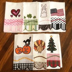 four napkins with different designs on them sitting on a wooden floor next to each other