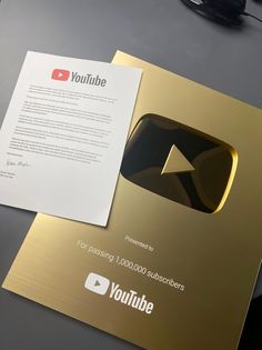 an image of a youtube logo on a gold folder with a white paper underneath it