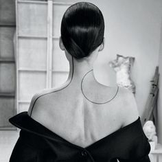 the back of a woman's neck with a tattoo on it