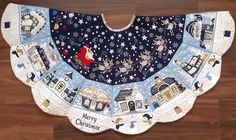 a blue and white bib with christmas images on it, sitting on a wooden floor