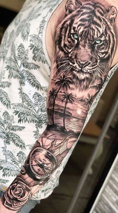 a man's arm with a tiger and palm tree tattoo on the left sleeve