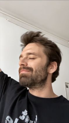 a man with a beard is looking up at the ceiling