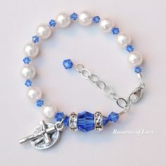 Celebrate the Baptism of a baby girl or boy with this beautiful crystal rosary bracelet featuring sapphire blue crystals and white pearls. This rosary bracelet features genuine crystals and crystal pearls throughout. The white crystal pearls (and letter bead if using) represent the Hail Mary prayers. They are separated by small sapphire blue crystal diamond-shaped crystals. The Our Father bead is a round sapphire blue crystal, surrounded by crystal rondelles on either side. The bracelet may be personalized with one single letter if you choose. Please choose between one sterling silver letter bead, one pewter bead, or one hand stamped sterling silver initial disk. **THE STERLING OR PEWTER LETTER BEAD OPTION WILL BE MADE WITH 9 PEARLS PLUS THE LETTER BEAD SO THE BRACELET FITS PROPERLY** (The Blue Beaded Bracelets With Birthstone, Adjustable Blue Rosary Bracelet With Cross, Adjustable Rosary Bracelet With Round Beads For Baptism, Blue Spiritual Jewelry For First Communion, Adjustable Rosary Bracelet With Miraculous Medal For First Communion, Adjustable 8mm Beads Rosary Bracelet For Baptism, Adjustable Rosary Bracelet With Round Beads For First Communion, Adjustable Rosary Bracelet For First Communion, Mary Prayers