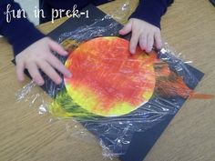 a child's hand on a piece of paper that has been made to look like an apple