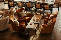 a living room filled with lots of furniture next to a dining table and chairs on top of a hard wood floor