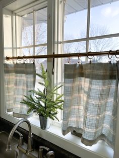 a potted plant sitting on top of a window sill next to a sink