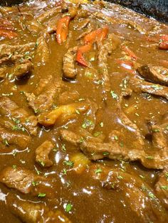 meat and carrots in gravy being cooked