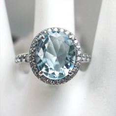 a ring with an aqua blue topaz surrounded by white diamonds