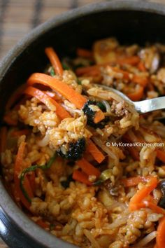 a bowl filled with rice, carrots and other vegetables