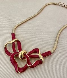 "Massive TRIFARI Bow Statement Necklace Vintage Choker Collar c. 1970s  -Elegant and chic! A rich red enamel bow motif pendant on a gold tone snake chain -Signed Trifari -Measures approximately 16 3/4\" long from end to end, fold over clasp. Bow measures approximately 3 3/16\" long x 2 1/4\" wide -Excellent vintage condition -Spring ring clasp" Retro Gold-tone Jewelry Gift, Retro Gold-tone Jewelry For Gift, Formal Red Enamel Necklaces, Formal Red Enamel Necklace, Gold Enamel Necklace For Party, Gold Enamel Party Necklace, Chic Evening Jewelry For Valentine's Day, Valentine's Day Chic Evening Jewelry, Elegant Enamel Necklace For Valentine's Day