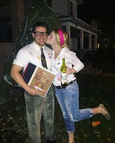 a man and woman standing next to each other in front of a tree with gifts