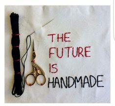 a pair of scissors sitting on top of a piece of cloth with the words the future is handmade