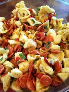 a glass bowl filled with pasta and vegetables