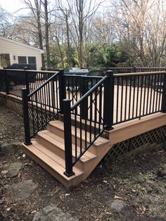 a wooden deck with black railing and handrails