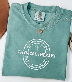 a green t - shirt with the words physical therapy on it next to a pair of scissors