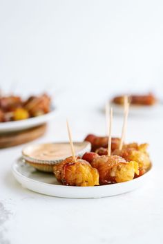 small appetizers with toothpicks on a white plate