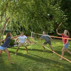 four people are playing volleyball in the yard