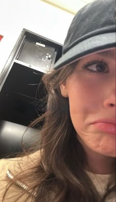 a close up of a person wearing a hat and looking at something in the oven