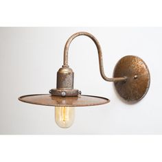 an old fashioned wall light with a bulb attached to the back of it's arm