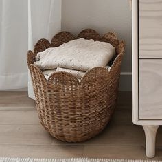 a wicker basket sitting on the floor next to a dresser