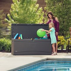 a woman and child near a pool with an inflatable ball