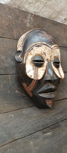 a wooden mask is hanging on the wall