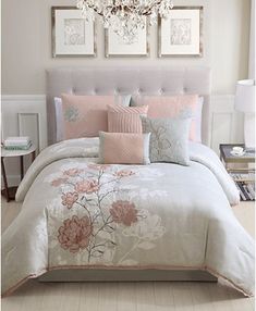 a bedroom with a chandelier and bedding in the corner, along with pictures on the wall