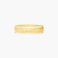 a yellow gold wedding band with an intricate design on the outside, and a textured surface