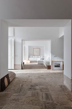 an empty living room with white furniture and wood accents on the walls, carpeted flooring