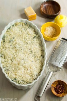 an uncooked pie crust with cheese and other ingredients on the table next to it