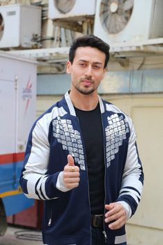 a young man giving the thumbs up sign