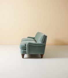 a blue chair sitting on top of a white floor next to a brown and tan wall