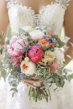 a bride holding a bouquet of flowers in her hands