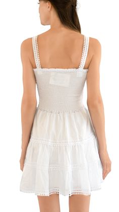 The top has a straight neckline and is sleeveless, featuring a smocked design. Its silhouette is A-line, and it's worn as a pullover style. Additionally, it is lined. White Dress With Smocked Bodice And Straight Neckline, Chic Fitted Sleeveless Smocked Dress, Sundress With Smocked Bodice And Straight Neckline, Elegant Sleeveless Smocked Top With Smocked Back, Chic Mini Dress With Smocked Bodice And Ruffled Straps, Chic Smocked Dress With Elastic Neckline For Day Out, Chic Sleeveless Cotton Smocked Dress, Chic Smocked Top With Square Neck, Chic Smocked Square Neck Top