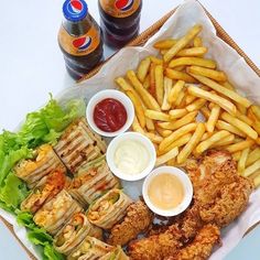 fried chicken, french fries and ketchup are served on a tray with lettuce