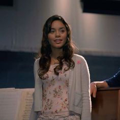 a woman standing in front of a piano