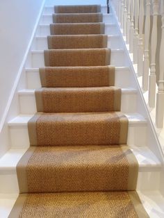 the carpeted stairs are lined with white railings