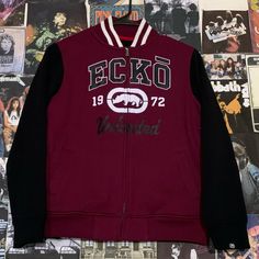 a maroon and black jacket with the ecko logo on it hanging from a wall