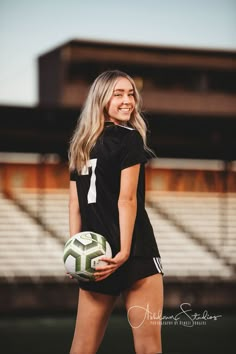 a beautiful young woman holding a soccer ball