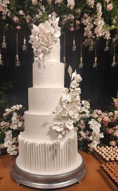 a large white wedding cake with flowers on top