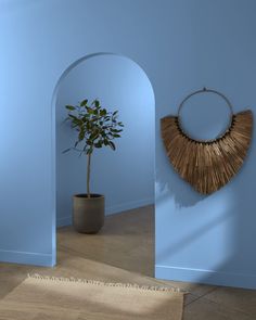 a potted plant sitting in the corner of a room next to a wall hanging