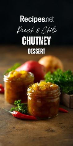 two jars filled with chutney dessert sitting on top of a wooden table next to vegetables