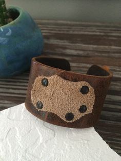 "This unique multi-color cuff bracelet is made of natural, rustic cowhide leather. I riveted a super soft piece of natural suede to the cuff for interest and detail. The riveted suede creates a \"pocket\" that will hold feathers or anything else your mind can imagine. I personally have a cuff in this style and I wear it with a feather. This cuff is ready to ship and will arrive attractively packaged and ready for gifting or for keeps. MEASUREMENTS & SPECIFICS: SIZE: one size - fits most men Adjustable Rugged Leather Bracelet, Adjustable Distressed Brown Leather Bracelet, Distressed Brown Leather Bracelets As Gift, Rustic Adjustable Leather Bracelet With Waxed Finish, Unique Brown Leather Bracelets, Rustic Vintage Brown Leather Bracelet, Adjustable Rustic Bracelet In Distressed Brown, Rugged Leather Bracelets, Rustic Hand Tooled Leather Bracelets