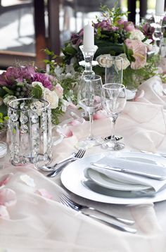 the table is set with silverware and flowers